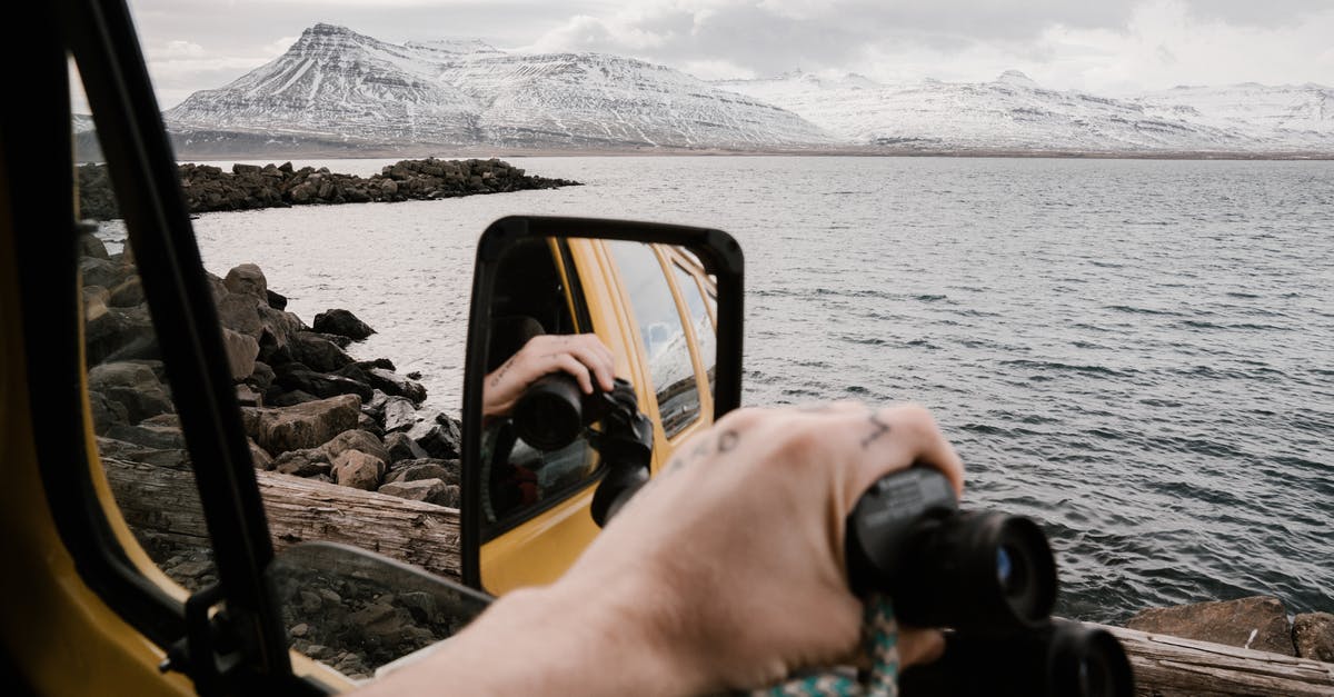 Do you have to water winter crops? - Unrecognizable traveler with binoculars admiring nature from car