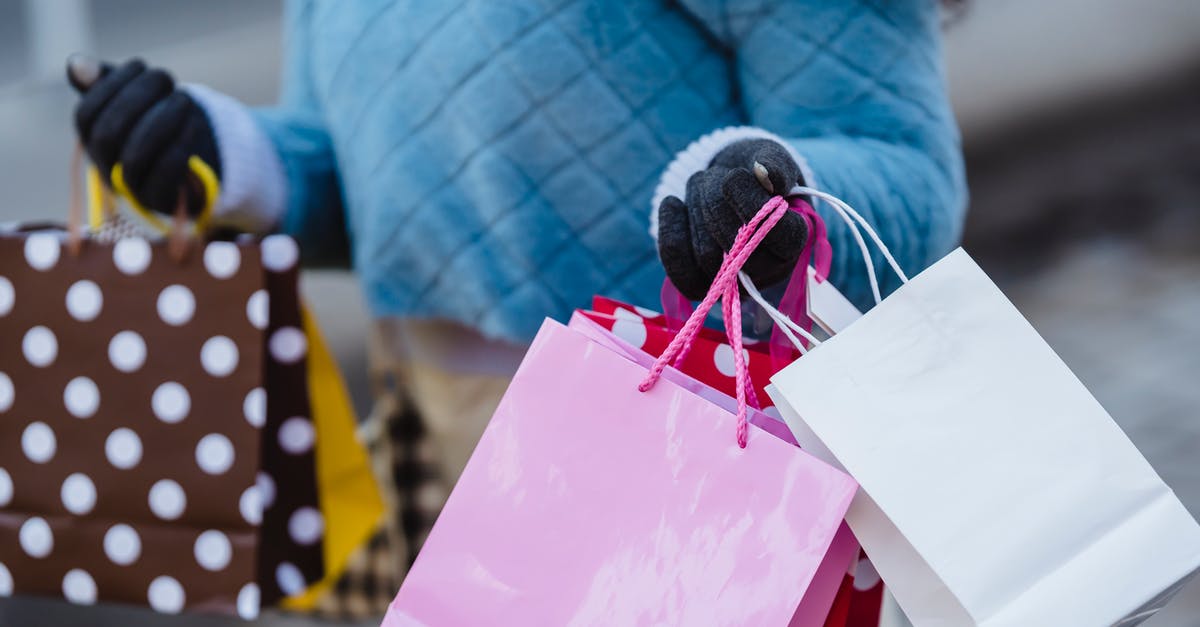 Do your levels and stat records carry over between different region servers? - Crop anonymous female in blue soft sweater with many different colorful gift bags on blurred background