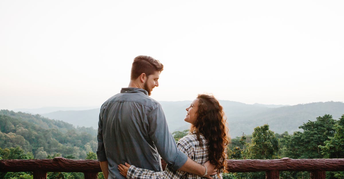 Does 'scenery' affect anything other than guests thoughts on the ride? - Smiling young couple embracing on terrace and admiring nature