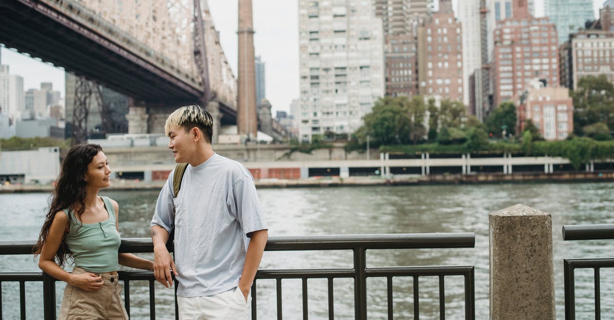 Does 'scenery' affect anything other than guests thoughts on the ride? - Calm multiethnic couple standing on waterfront of megapolis