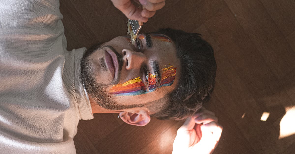 Does a portal to Alfheim draw mana equally from the two pools? - From above young calm male painting bright multicolored lines on face by using paintbrush while lying on parquet and looking away pensively