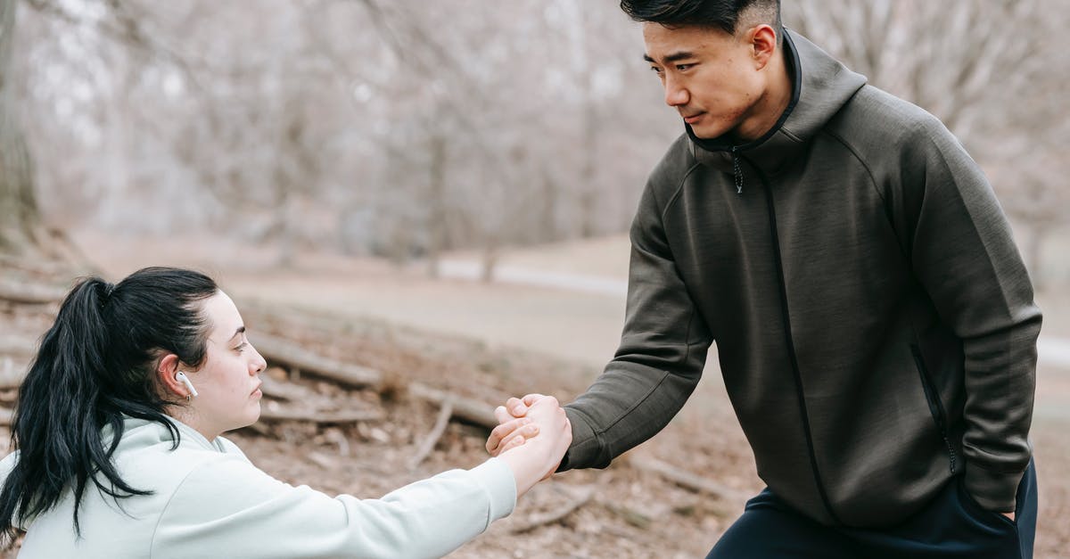 Does an active radio aid stealth in Fallout 4? - Young Asian male in sportswear giving hand to plump female fell on ground while training together in autumn leafless forest