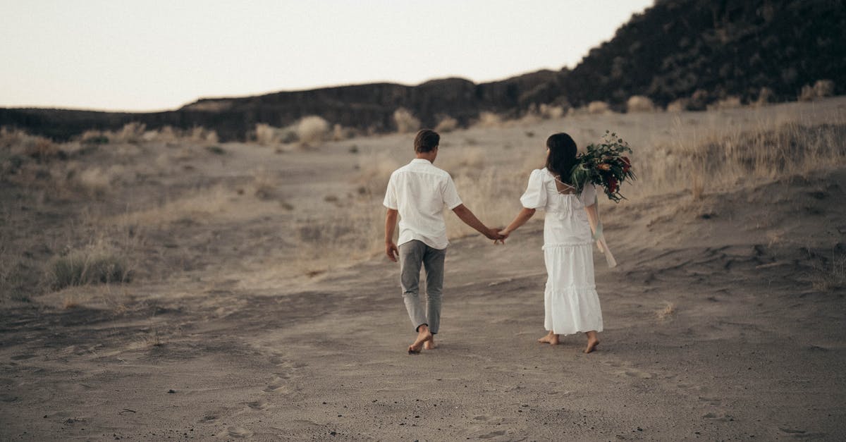 Does an asteroid field event affects the 'Tactical Approach' achievement? - Full body back view of anonymous bride with flowers and groom holding hands while strolling on sandy field during wedding celebration