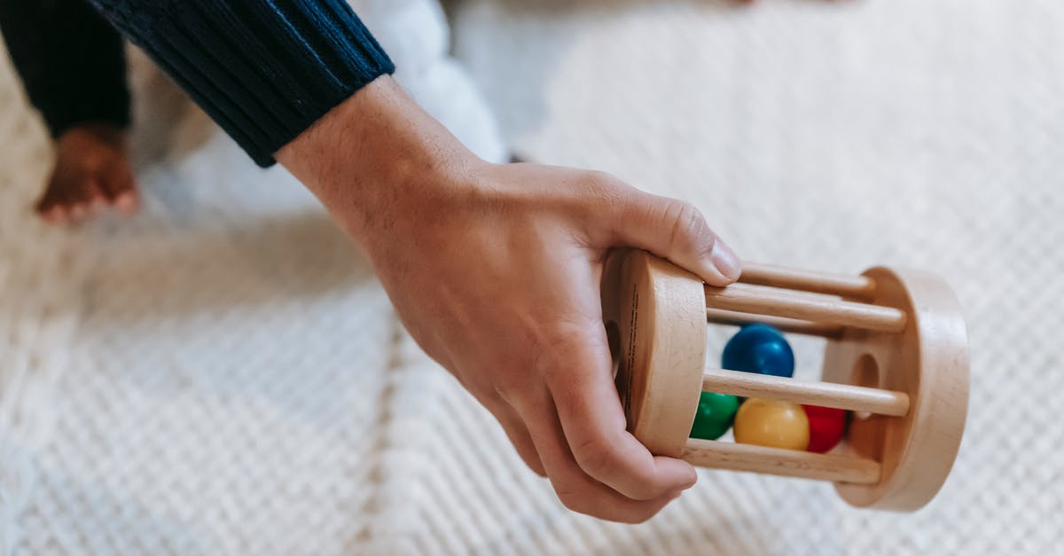 Does anything carry over from tales of berseria's free steam demo to a potential purchase? - From above of crop anonymous male parent carrying colorful wooden rattle with small balls while spending time with little babyb