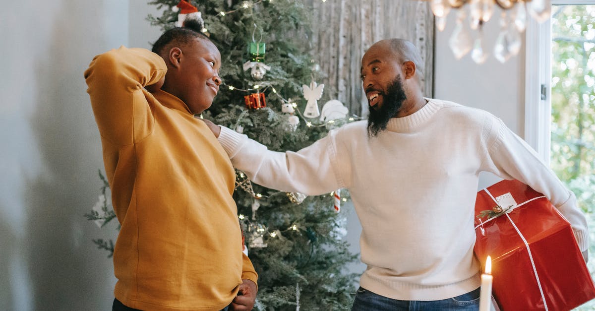 Does anything happen if I give a severed head item to a character with the same name? - Happy bearded African American man with red box touching shoulder of cheerful black son with hand behind head during Christmas holiday while looking at each other