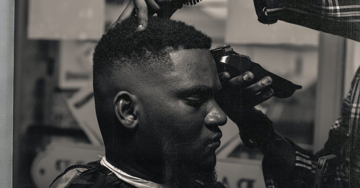 does FE Heroes treat weapons as skills? - Black and white side view calm adult African American male sitting in barber shop while crop hairdresser trimming hair