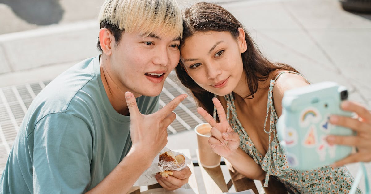 Does GTA V activate on Steam? - Cheerful Asian couple taking selfie in cafe