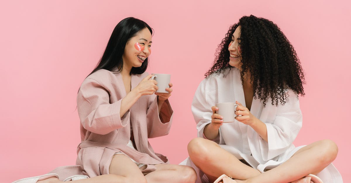 Does having a Sub acct add charges? - Two women in bathrobes sitting on floor and having break with cup of tea