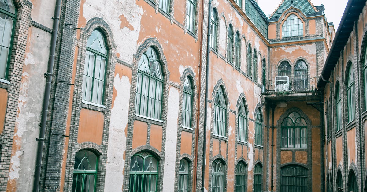 Does hit location matter for damage? - Exterior of aged cement structure with brick elements and glass windows in city