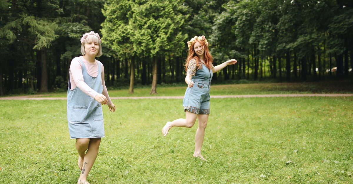 Does hopping have an advantage? - Woman in White Shirt and Blue Denim Shorts Holding Girl in White Shirt on Green Grass