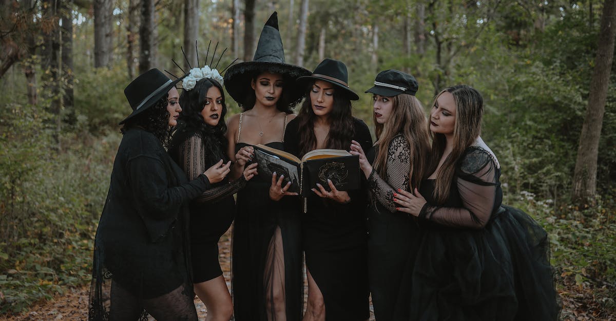 Does infusing chimes affect spell damage? - Group of women dressed as witch coven reading spell book in forest