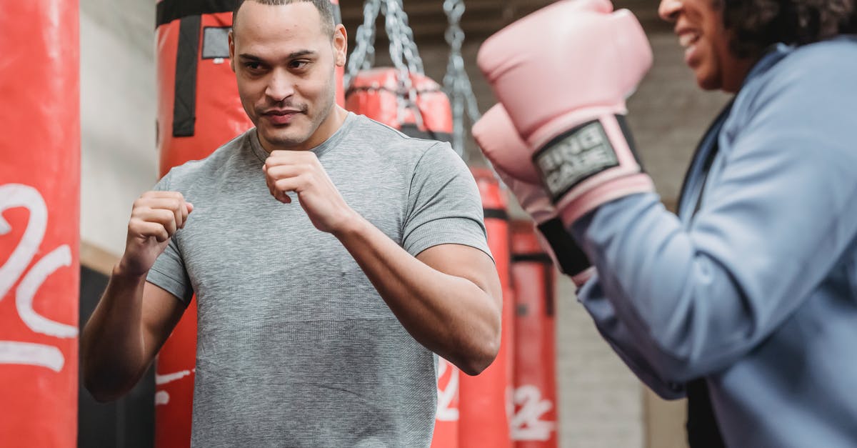 Does it help my team's gym if I train there, but lose? - Focused ethnic male with fists training with black woman