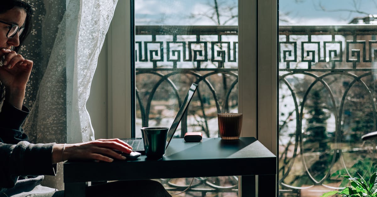 Does Magic 2015 For PC Change The Location Of The Multiplayer Chat Window? - Crop side view of female in casual clothing and eyeglasses sitting at table near window and lounging with laptop