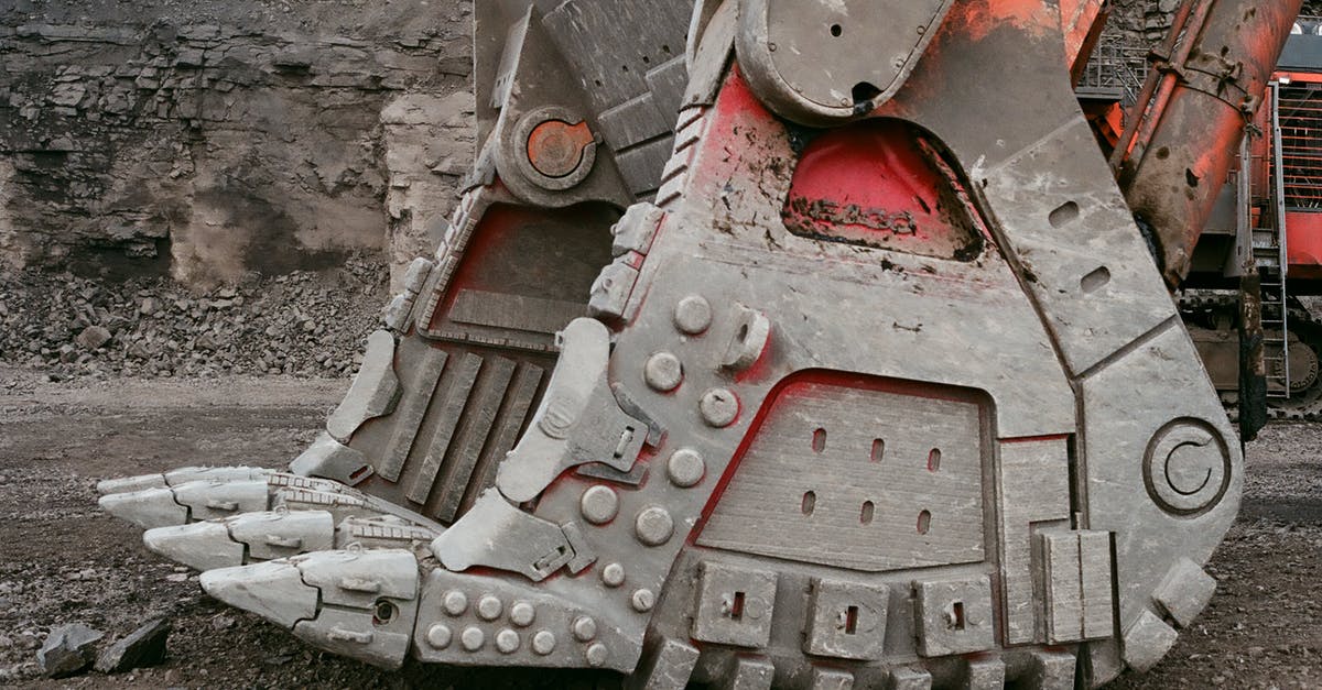 Does Malphite's E (the ground smash) work when his enemies are airborne? - Modern mining loader bucket for lifting heavy loads located on ground in quarry against gray stone wall on daytime