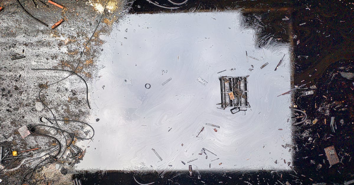 Does Poison damage scale with Magic? - Top view of black reflecting dirty river contaminated with oil products and litter