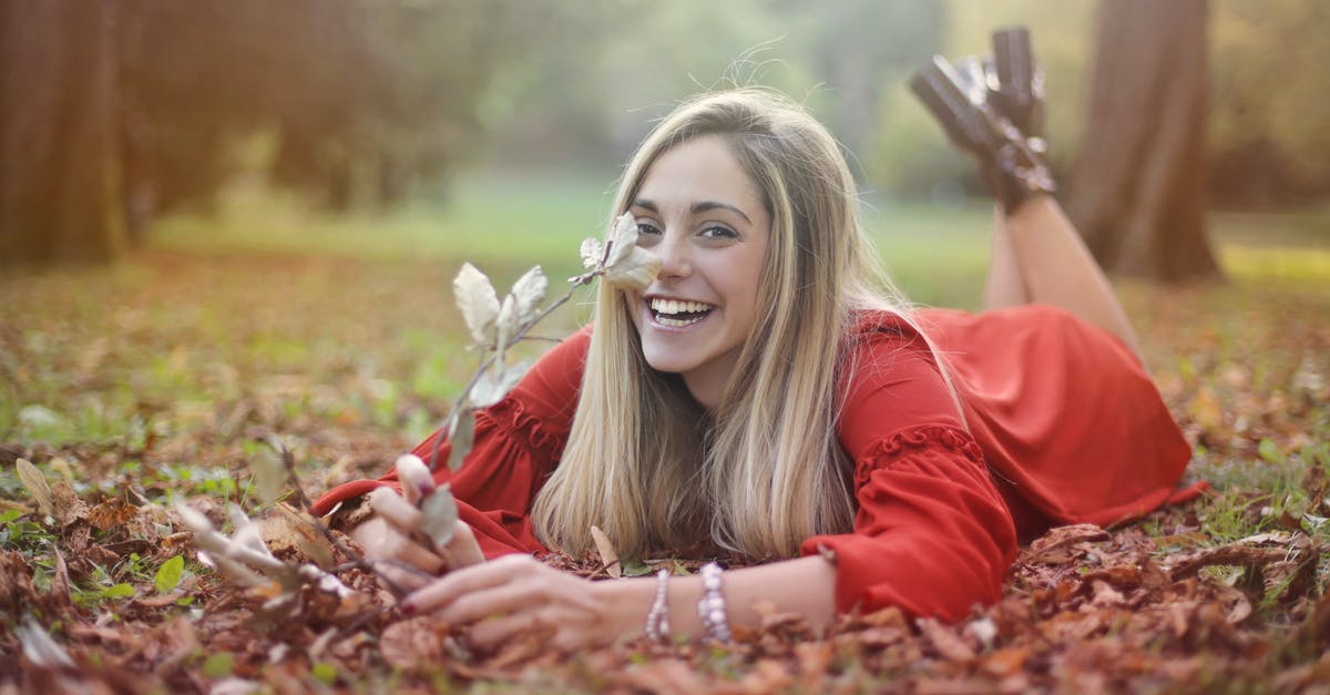 Does pressing down on the analog sticks increase the likelyhood of stick drift? - Selective Focus Photo of Laughing Woman in a Red Long Sleeve Dress Lying on Dry Leaves While Holding a Stick with Dry Leaves