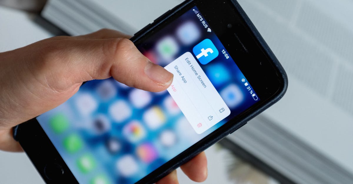 Does Removing a User From PS4 Delete the Account? - From above of crop anonymous person touching blurred cellphone screen while opening app and choosing option from pop up window