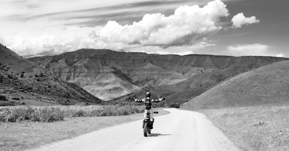Does riding a mount influence resources detection ability? - Black and white back view of anonymous biker with outstretched arms riding motorbike on curved roadway between mounts under cloudy sky Does riding a mount influence resources detection ability? - Black and white back view of anonymous biker with outstretched arms riding motorbike on curved roadway between mounts under cloudy sky