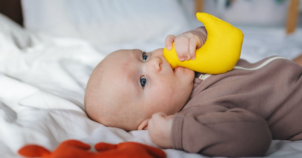 Does silence affect hero passives? - Side view of adorable newborn in brown wear lying on bed with clenched fist and yellow toy in mouth Does silence affect hero passives? - Side view of adorable newborn in brown wear lying on bed with clenched fist and yellow toy in mouth