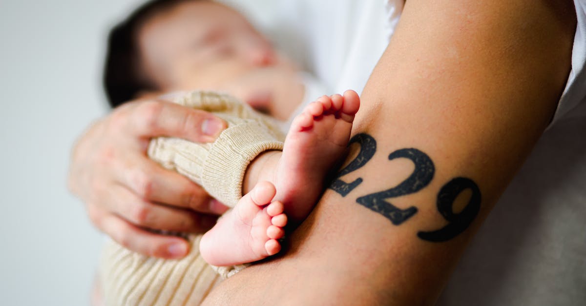 Does silence affect hero passives? - Side view of crop anonymous parent with tattoo holding adorable sleeping barefooted baby in arms at home Does silence affect hero passives? - Side view of crop anonymous parent with tattoo holding adorable sleeping barefooted baby in arms at home