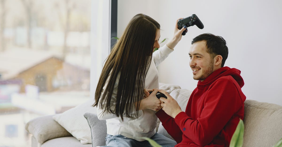 Does Terraria have controller compatibility? - Unrecognizable woman playing with cheerful bearded boyfriend using game pad while sitting on sofa and having fun in apartment in daylight Does Terraria have controller compatibility? - Unrecognizable woman playing with cheerful bearded boyfriend using game pad while sitting on sofa and having fun in apartment in daylight