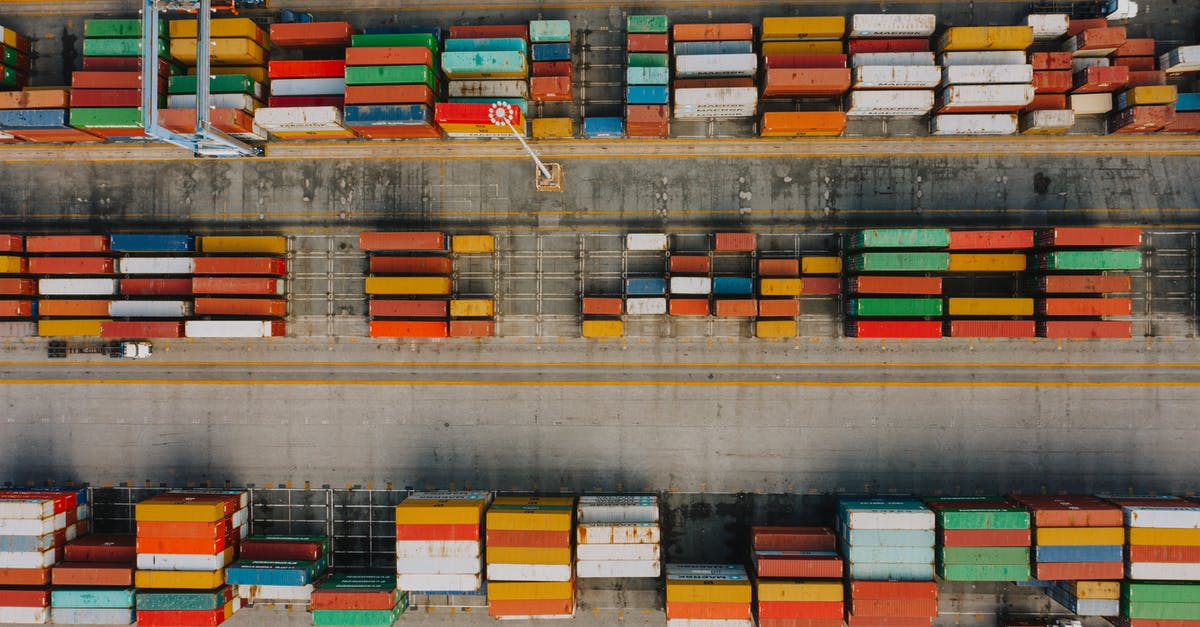 Does the different coloured solar system mean anything - Drone view of various colorful cargo containers placed in rows on asphalt in daytime Does the different coloured solar system mean anything - Drone view of various colorful cargo containers placed in rows on asphalt in daytime