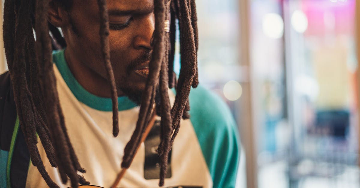 Does the difficulty you play on have any effect on gwent? - Crop stylish black musician singing song while playing guitar indoors