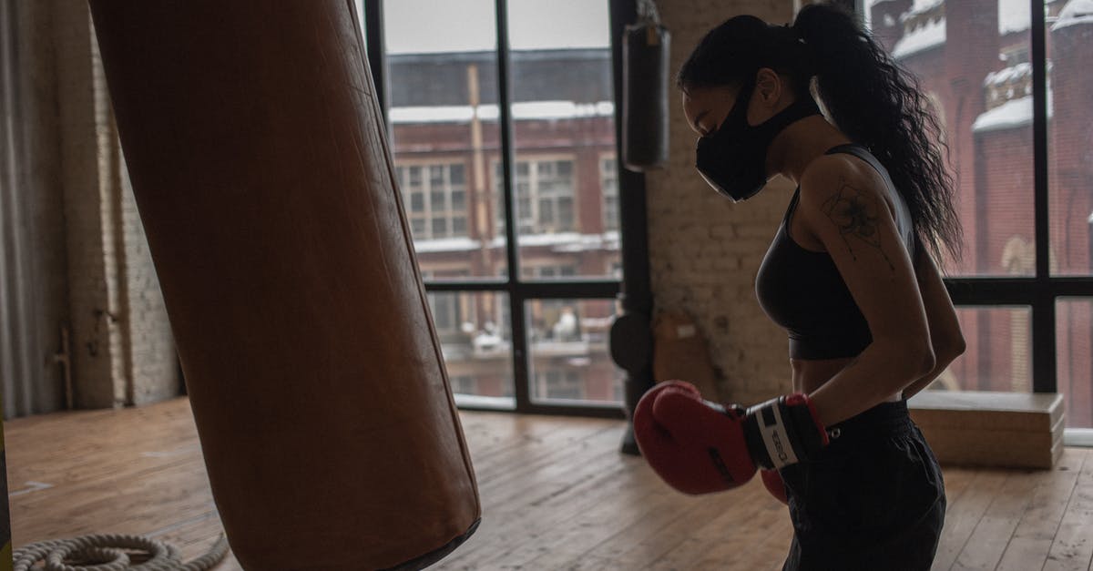 Does the DLT-19 Heavy Blaster have any advantage over the RT-97C? - Side view of ethnic female boxer in textile mask against heavy bag during workout in gym