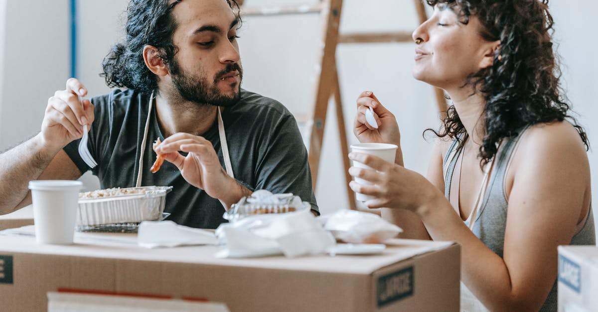 Does the Hot Tub in the Castle allow me to improve relationships? - Ethnic couple enjoying delicious takeaway lunch in renovated house