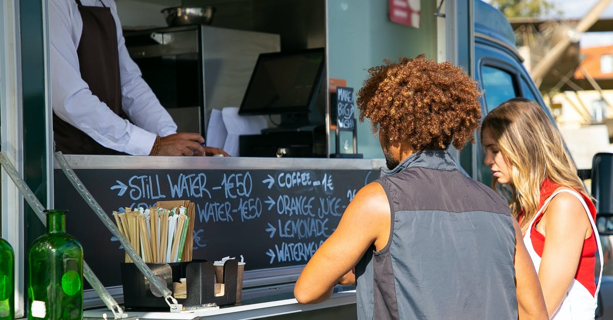 Does the order in which you pick up items matter? - Multiethnic couple standing together near food truck with seller and selecting dishes from menu in sunny day Does the order in which you pick up items matter? - Multiethnic couple standing together near food truck with seller and selecting dishes from menu in sunny day