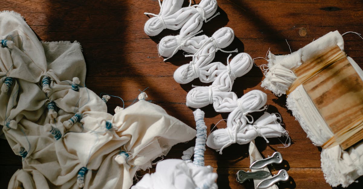 Does the quality of white items give different craft results? - Folded fabrics tied with threads for tie dye on desk