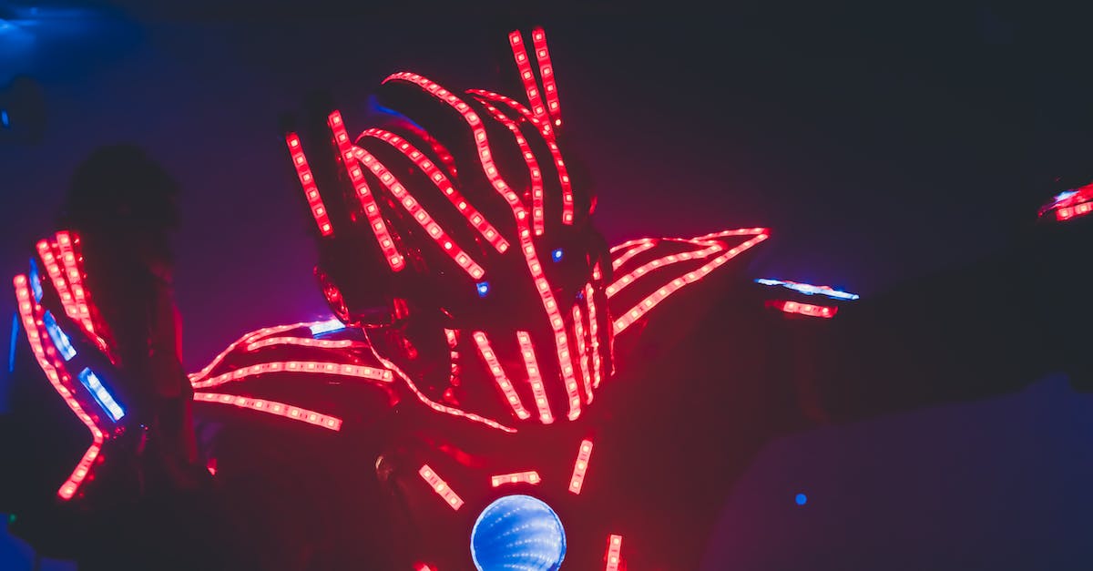 Does the World of Warcraft character boost upgrade both professions? - Unrecognizable man in costume with glowing light emitting diodes giving performance in twilight