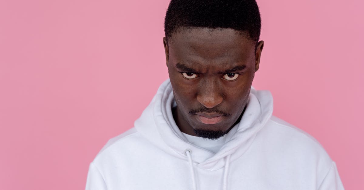 Does this character die in Resident Evil 7? - Angry black man in hoodie against light pink background