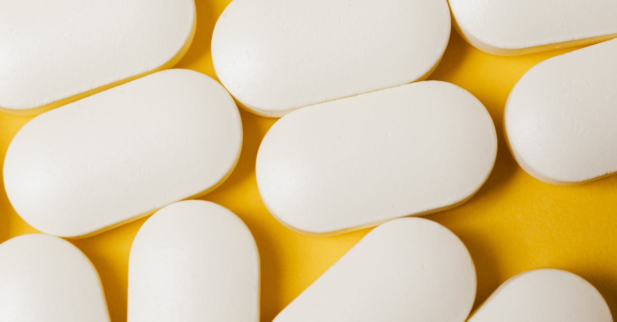 Does timely first aid speed up a wounded soldier's recovery? - From above closeup of white ellipse shaped medical pills placed on bright yellow surface