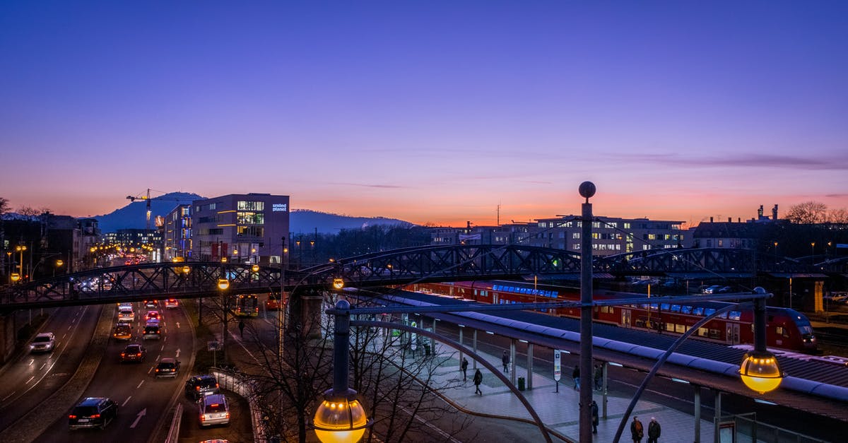 Does transport building reduce traffic on roads? - People Walking on Train Station Near Highway in Distant of Buildings Does transport building reduce traffic on roads? - People Walking on Train Station Near Highway in Distant of Buildings