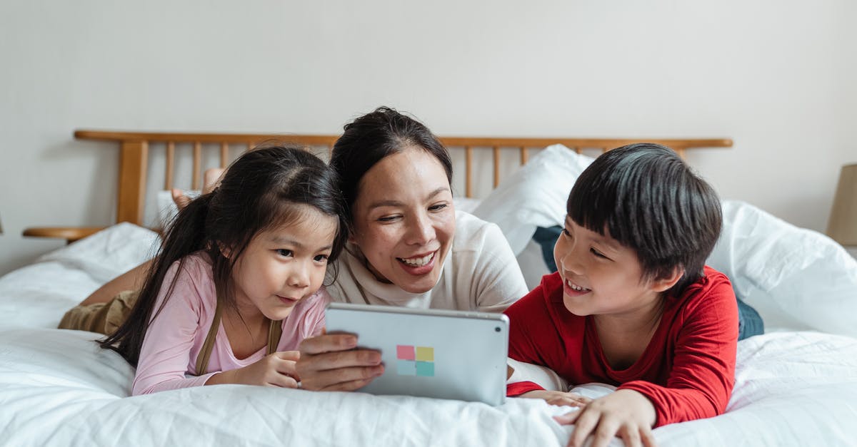 Does using Spark of light affect the story? - Cheerful ethnic mother watching video via tablet with kids on bed