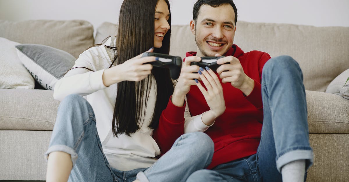 Does using the Console Commands negatively affect me? - Happy couple sitting on carpet while playing videogame