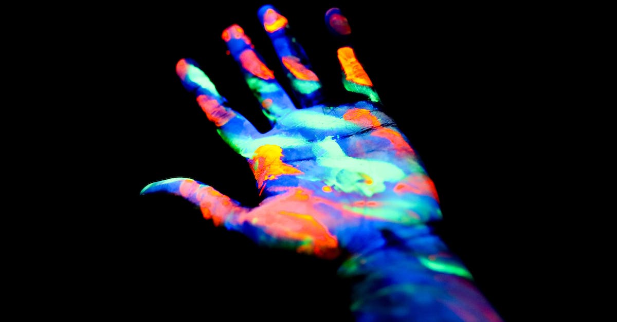 Does UV Light Kill the Volatiles? - Crop anonymous persons hand painted in neon colors in darkness
