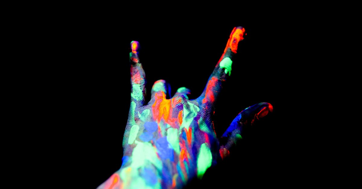 Does UV Light Kill the Volatiles? - Faceless persons hand covered with neon paints showing shaka sign