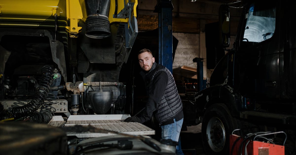Does workshop provide any unique bonuses? - Woman in Blue and White Striped Long Sleeve Shirt Standing Beside Black and Yellow Heavy Equipment