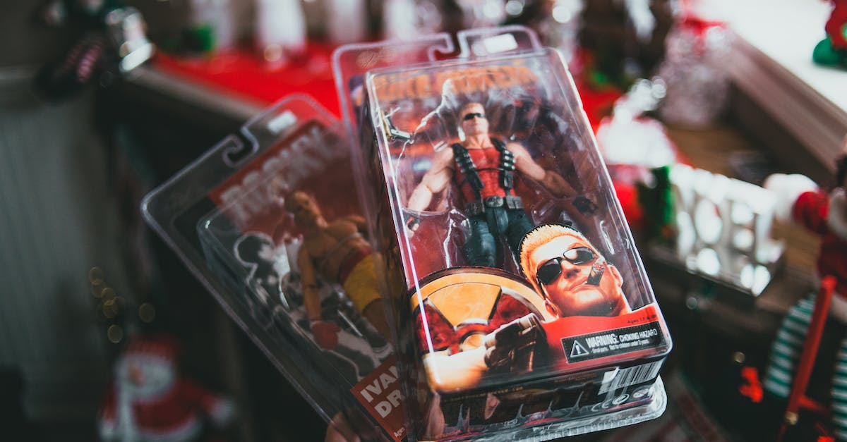 Does your team's faction limit affect hero choice? - High angle of crop faceless person demonstrating packed toys of strong comic characters in souvenir shop during Christmas holidays