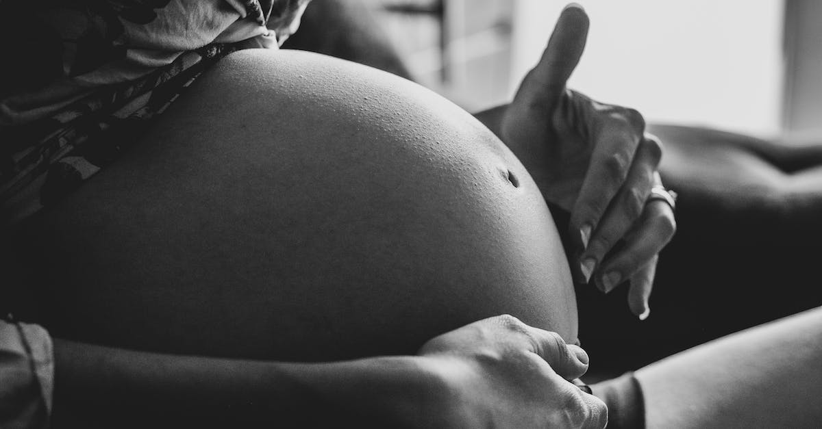 Don't touch anything - what does the top left panel do? - Crop pregnant woman touching belly belly while resting on couch
