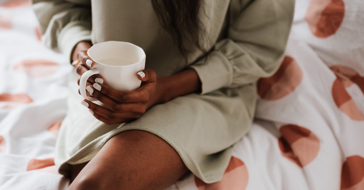 DOTA 2: Minimap crosses to another shape - Crop anonymous ethnic female with cup of aqua sitting with crossed legs on bed blanket at home