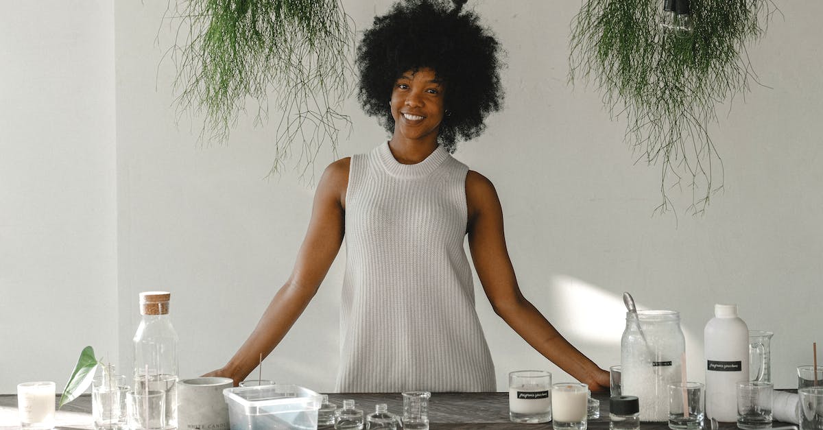 Dota 2 Workshop Content downloading, DLC unticked - Cheerful African American craftswoman standing at table with handmade candles and assorted equipment while looking at camera