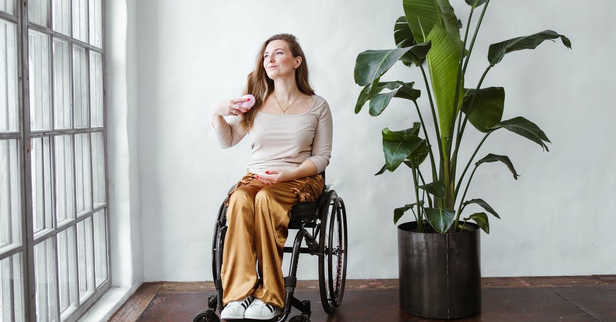 Downloading Minecraft (Java Edition) on Windows 11 - Woman in White Tank Top and Orange Skirt Sitting on Black Wheel Chair