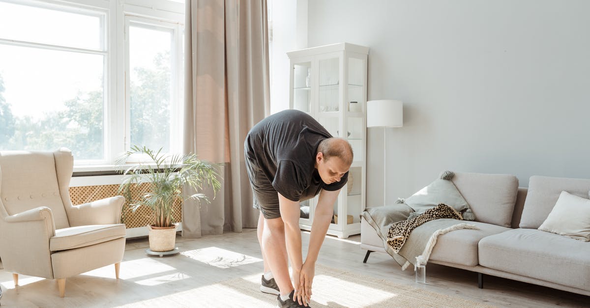 Downloading Minecraft (Java Edition) on Windows 11 - Man in Gray T-shirt and Black Shorts Kneeling on Floor