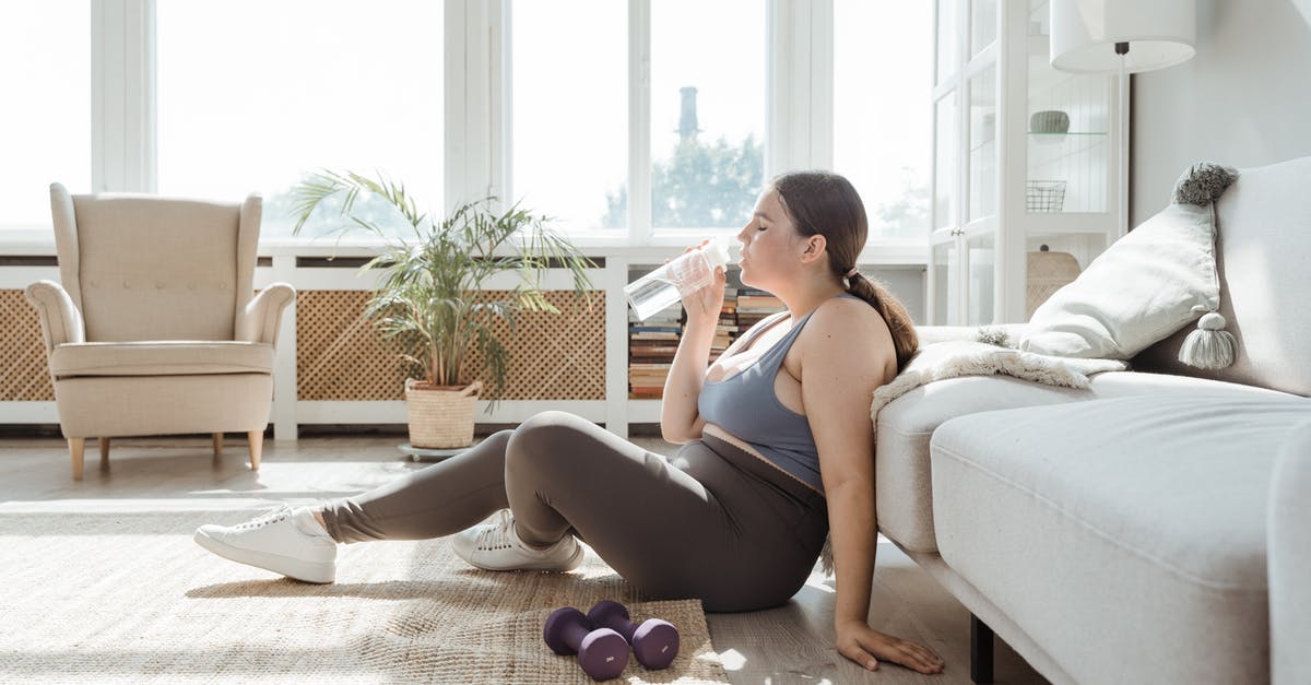 Downloading Minecraft (Java Edition) on Windows 11 - Woman in Blue Tank Top and Black Shorts Sitting on White Couch