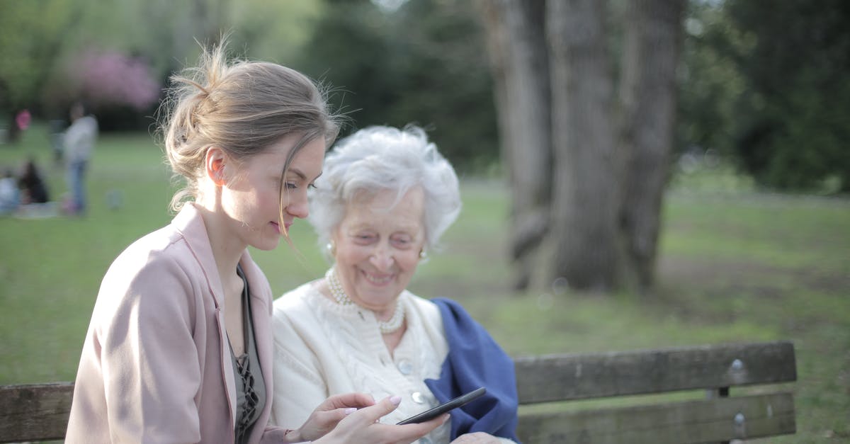 Dragon Age Inquisition Content installing - Side view of smiling adult female helping aged mom in using of mobile phone while sitting together in park Dragon Age Inquisition Content installing - Side view of smiling adult female helping aged mom in using of mobile phone while sitting together in park
