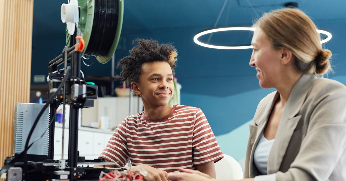Dweller from the Future? [duplicate] - Positive young male engineer sitting at table with woman and working together on project in light room