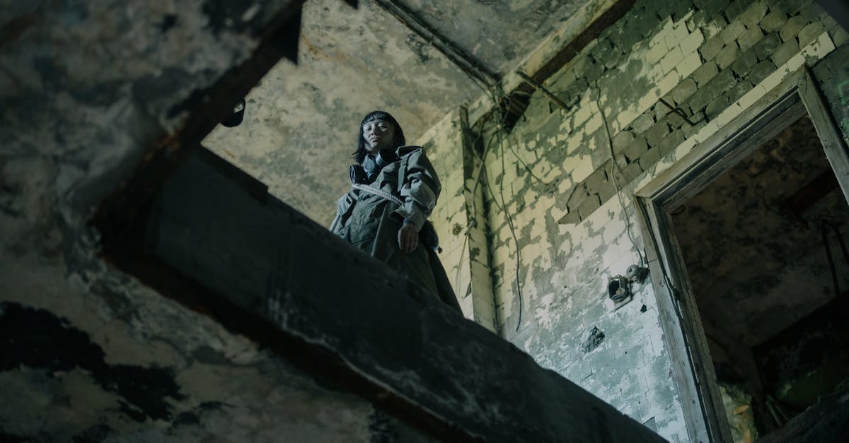 Dweller from the Future? [duplicate] - Man in Black Jacket and Pants Sitting on Concrete Wall